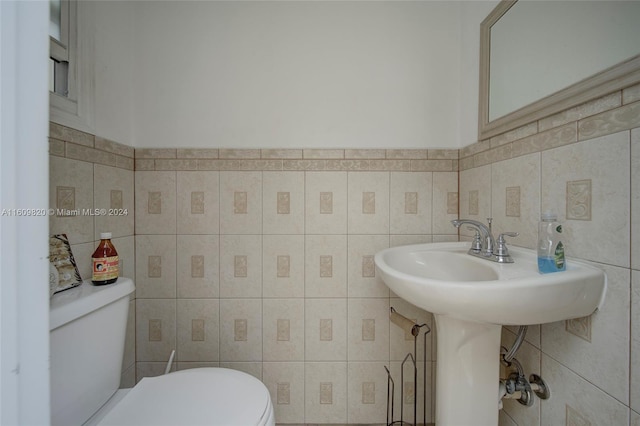 bathroom with backsplash, toilet, and tile walls