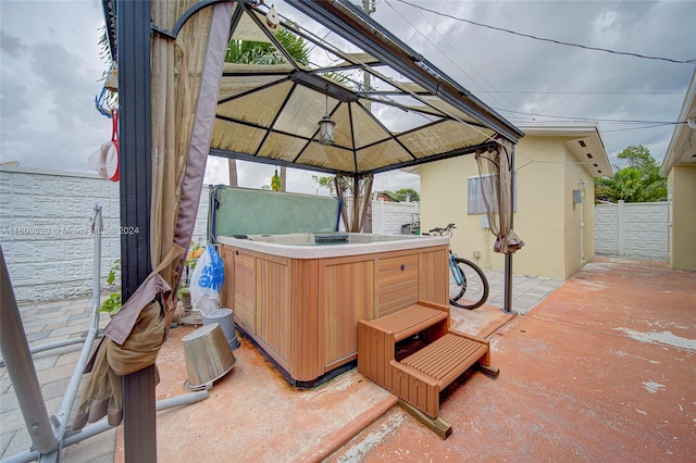 view of patio / terrace with a hot tub and a gazebo