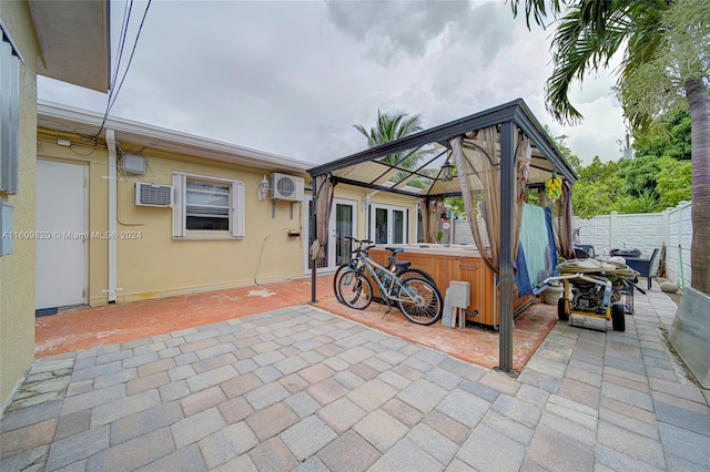 view of patio / terrace featuring a wall mounted AC and a gazebo