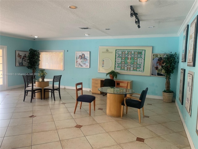 dining space featuring crown molding, light tile patterned floors, a textured ceiling, and rail lighting