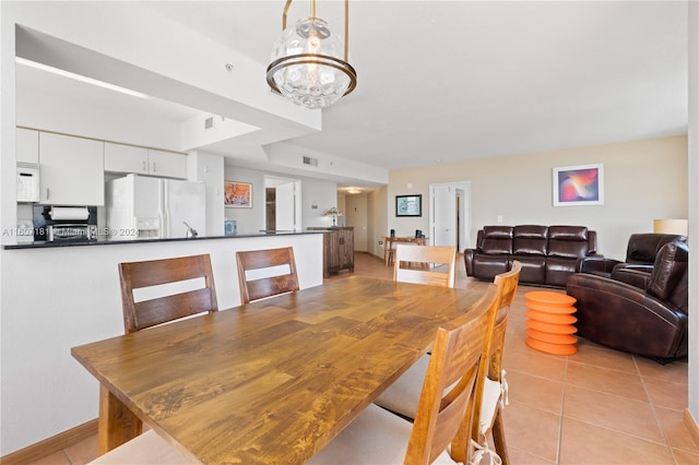 dining area with a notable chandelier and light tile patterned floors