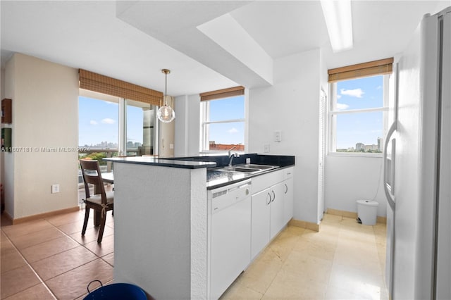 kitchen with a wealth of natural light, white appliances, and white cabinetry