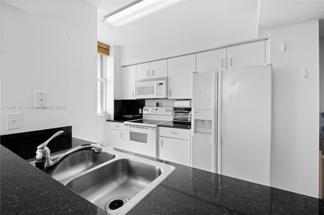 kitchen featuring white cabinets, dark stone counters, sink, and white appliances