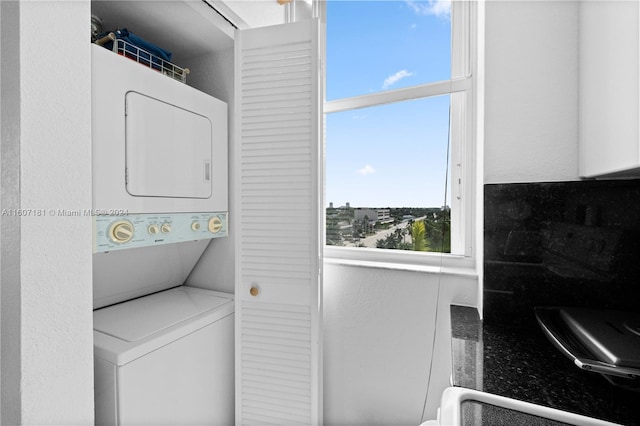 washroom with a wealth of natural light and stacked washer and clothes dryer