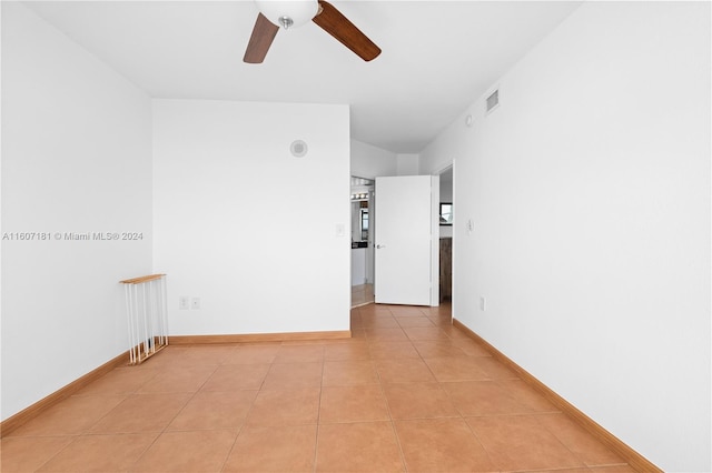 tiled spare room featuring ceiling fan