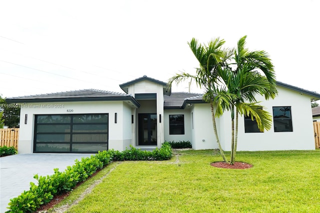 view of front of home with a front yard and a garage