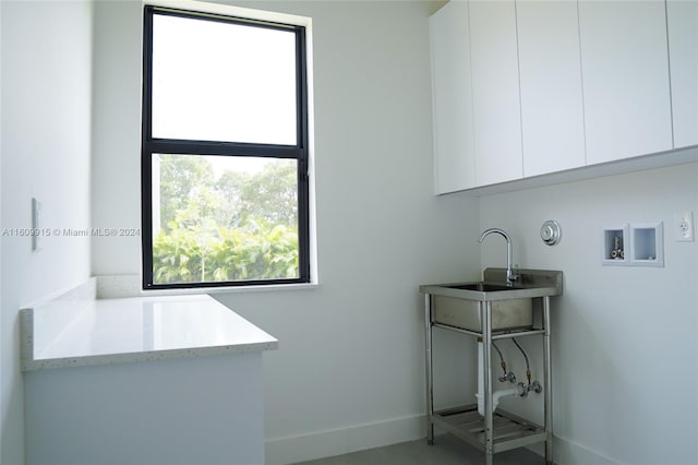 clothes washing area with hookup for a washing machine and cabinets