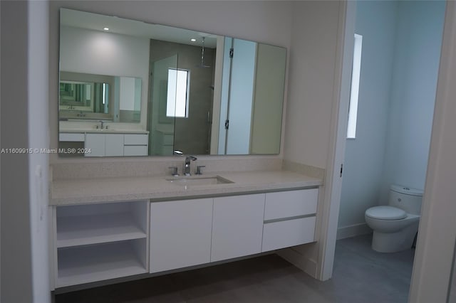 bathroom featuring vanity, a shower, and toilet