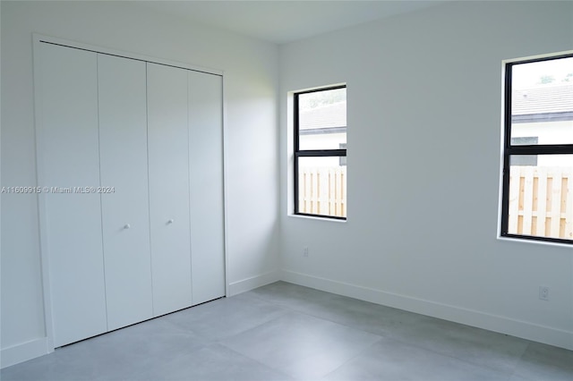 unfurnished bedroom featuring a closet and multiple windows