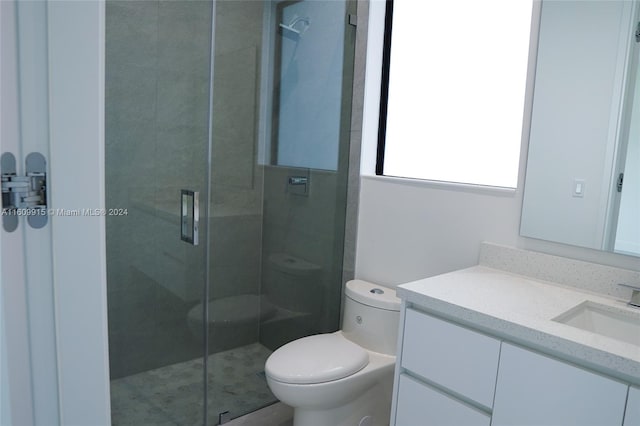 bathroom with toilet, an enclosed shower, and vanity