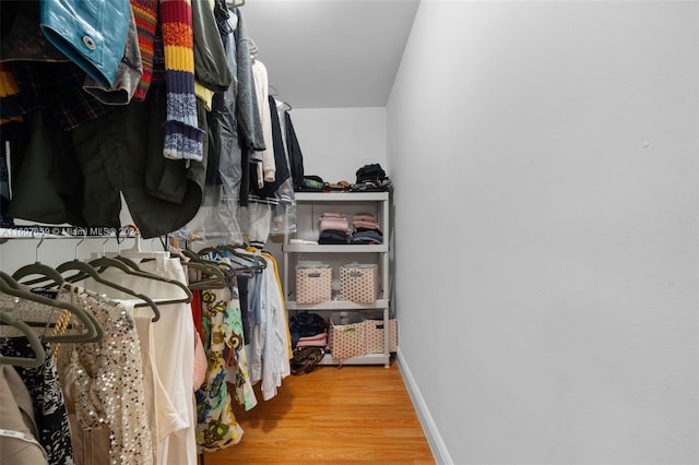 walk in closet with light hardwood / wood-style flooring