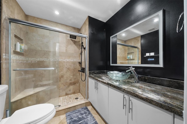 bathroom featuring tile flooring, walk in shower, vanity, and toilet