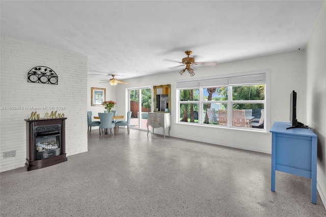 living room featuring ceiling fan and a fireplace