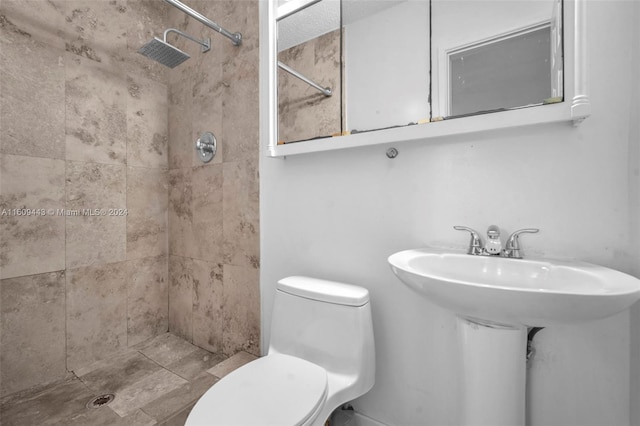 bathroom with tiled shower and toilet