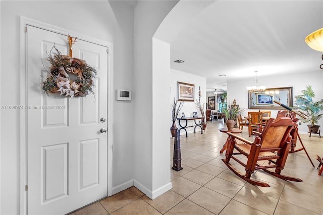 foyer entrance featuring a chandelier and light tile floors