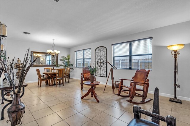 sitting room featuring a chandelier and light tile floors