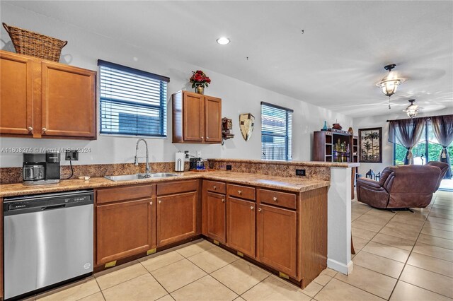 kitchen with sink, dishwasher, kitchen peninsula, and light tile flooring