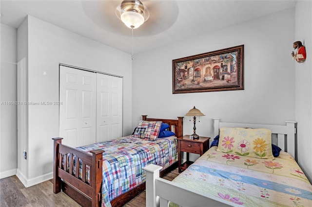 bedroom with ceiling fan, a closet, and wood-type flooring