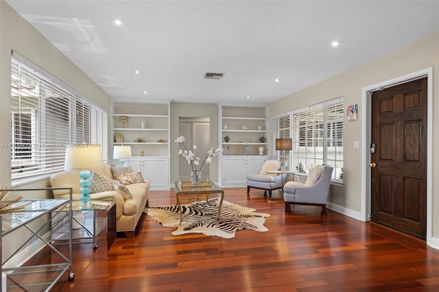 living area with built in shelves and dark wood-type flooring