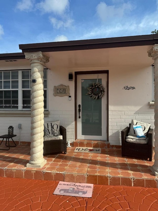 entrance to property featuring brick siding