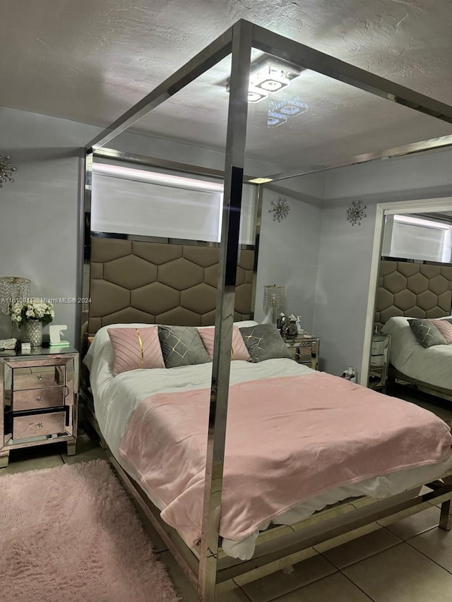 bedroom featuring a textured ceiling and tile patterned floors