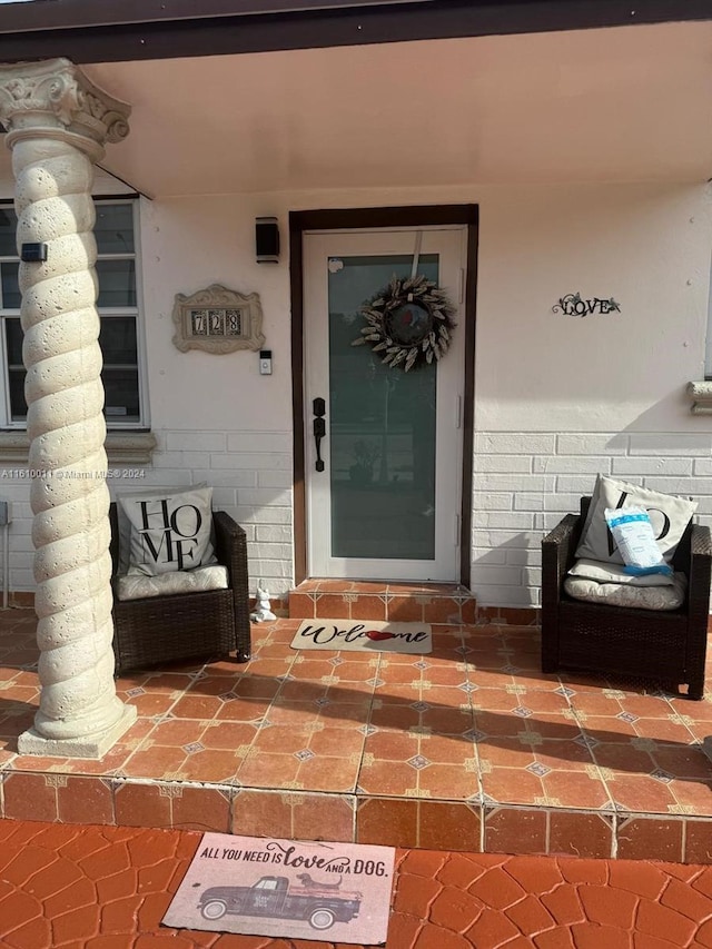 doorway to property featuring brick siding