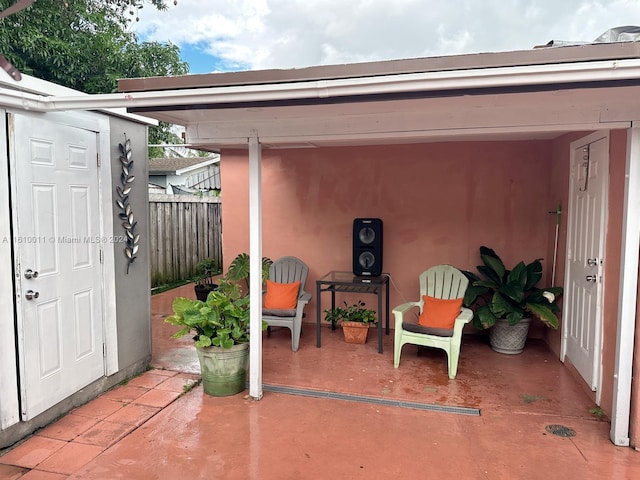 view of patio / terrace featuring fence and an outbuilding