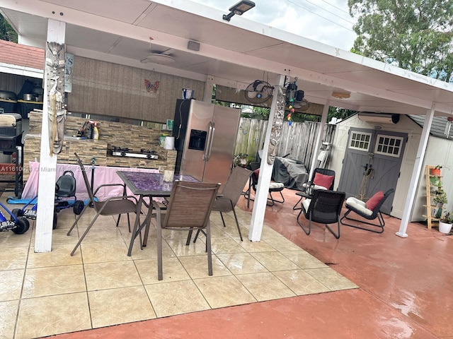 view of patio / terrace with a storage shed, an outdoor structure, and outdoor dining space