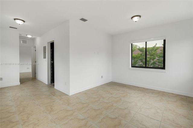 unfurnished room with light tile patterned floors and electric panel