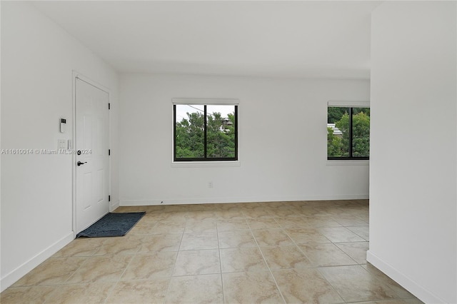 tiled empty room featuring a healthy amount of sunlight