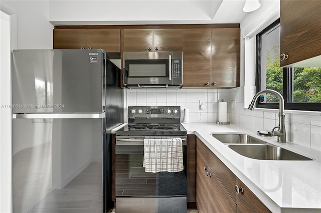 kitchen with backsplash, sink, and stainless steel appliances