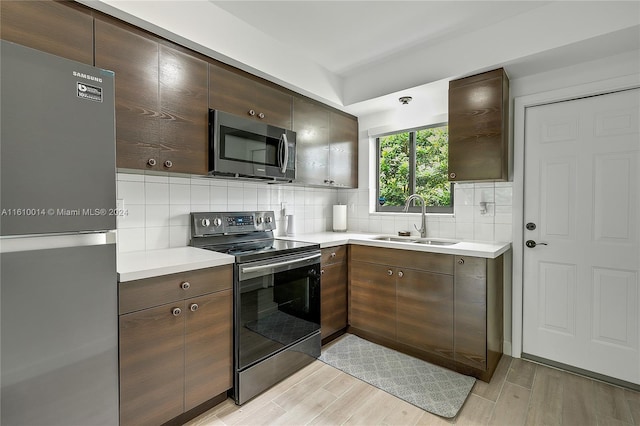 kitchen with tasteful backsplash, sink, stainless steel appliances, and dark brown cabinets