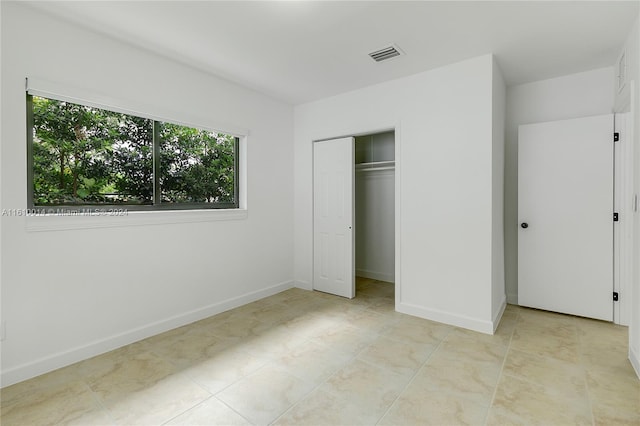 unfurnished bedroom featuring light tile patterned floors and a closet