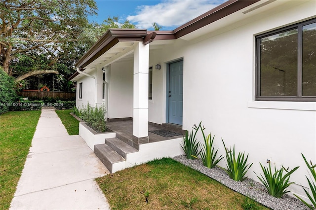 view of exterior entry featuring a yard