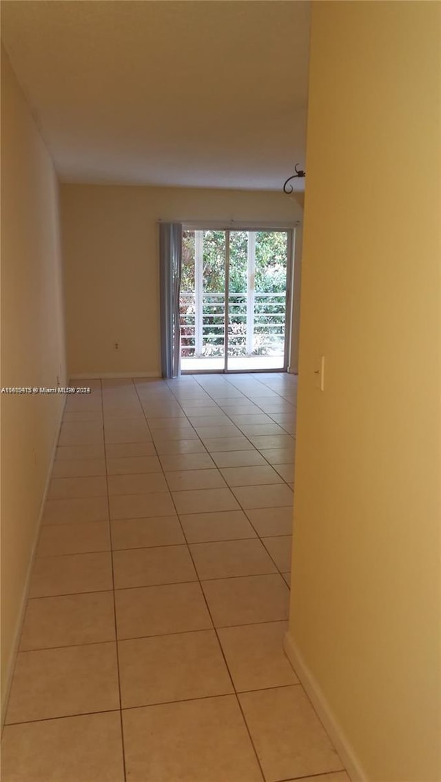 unfurnished room featuring light tile patterned floors and baseboards