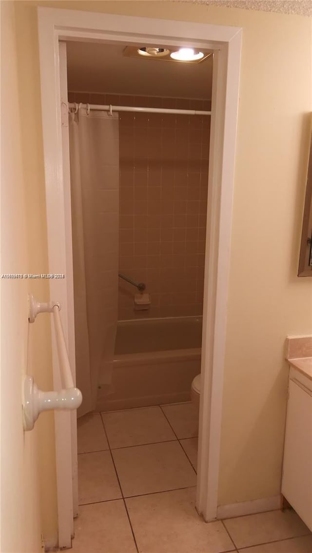 full bathroom with toilet, vanity, baseboards, tile patterned floors, and shower / bathtub combination with curtain