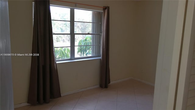 unfurnished room with baseboards and light tile patterned floors