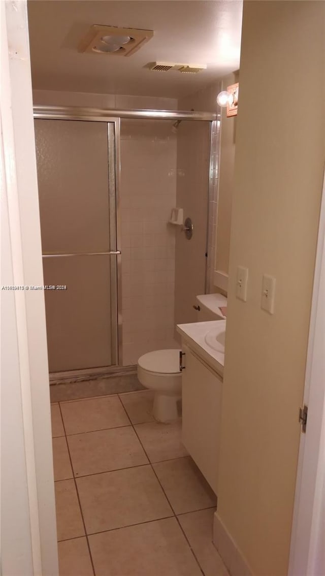 full bathroom featuring visible vents, toilet, tile patterned floors, vanity, and a shower stall