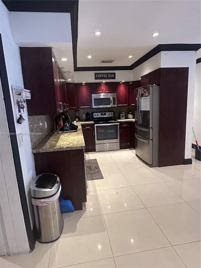 kitchen featuring sink, decorative backsplash, light stone countertops, light tile patterned flooring, and stainless steel appliances