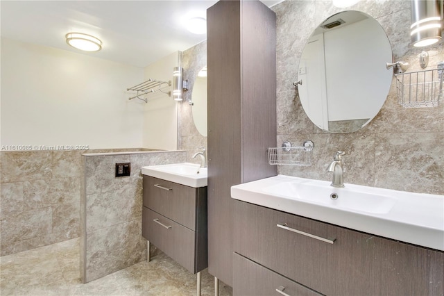 bathroom with vanity and tile walls