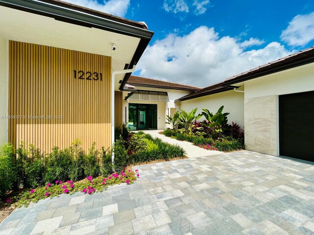 12231 SW 2nd St, Plantation, FL 33325 - view of exterior entry with stucco siding and a security system