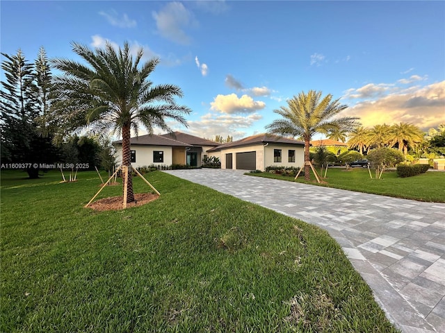 view of front of home with a garage and a yard