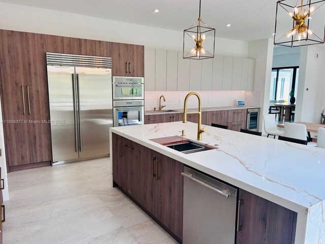 12231 SW 2nd St, Plantation, FL 33325 - kitchen featuring appliances with stainless steel finishes, a sink, a chandelier, beverage cooler, and recessed lighting