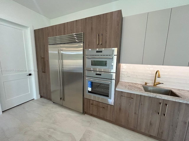 12231 SW 2nd St, Plantation, FL 33325 - kitchen featuring stainless steel appliances, a sink, tasteful backsplash, modern cabinets, and light stone counters