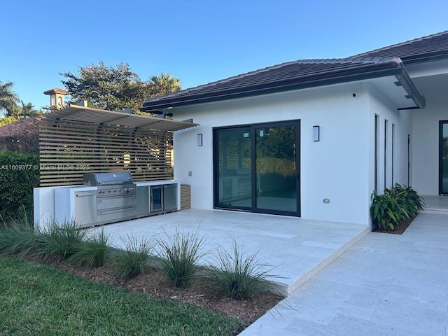 rear view of house featuring a patio, area for grilling, and stucco siding