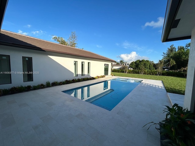 view of swimming pool featuring a patio area and a yard