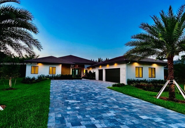 12231 SW 2nd St, Plantation, FL 33325 - view of front of house with a garage, decorative driveway, a yard, and stucco siding