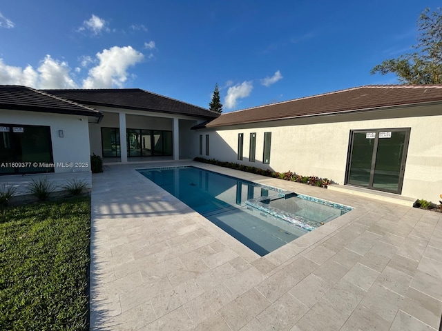 view of swimming pool featuring a patio area and an in ground hot tub