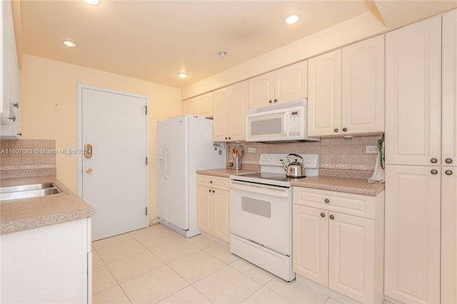 kitchen featuring sink, light tile patterned floors, backsplash, and white appliances