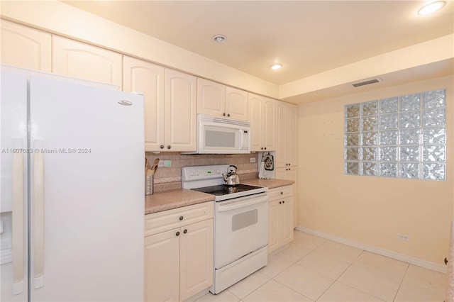 kitchen featuring white cabinetry, tasteful backsplash, light tile patterned floors, and white appliances